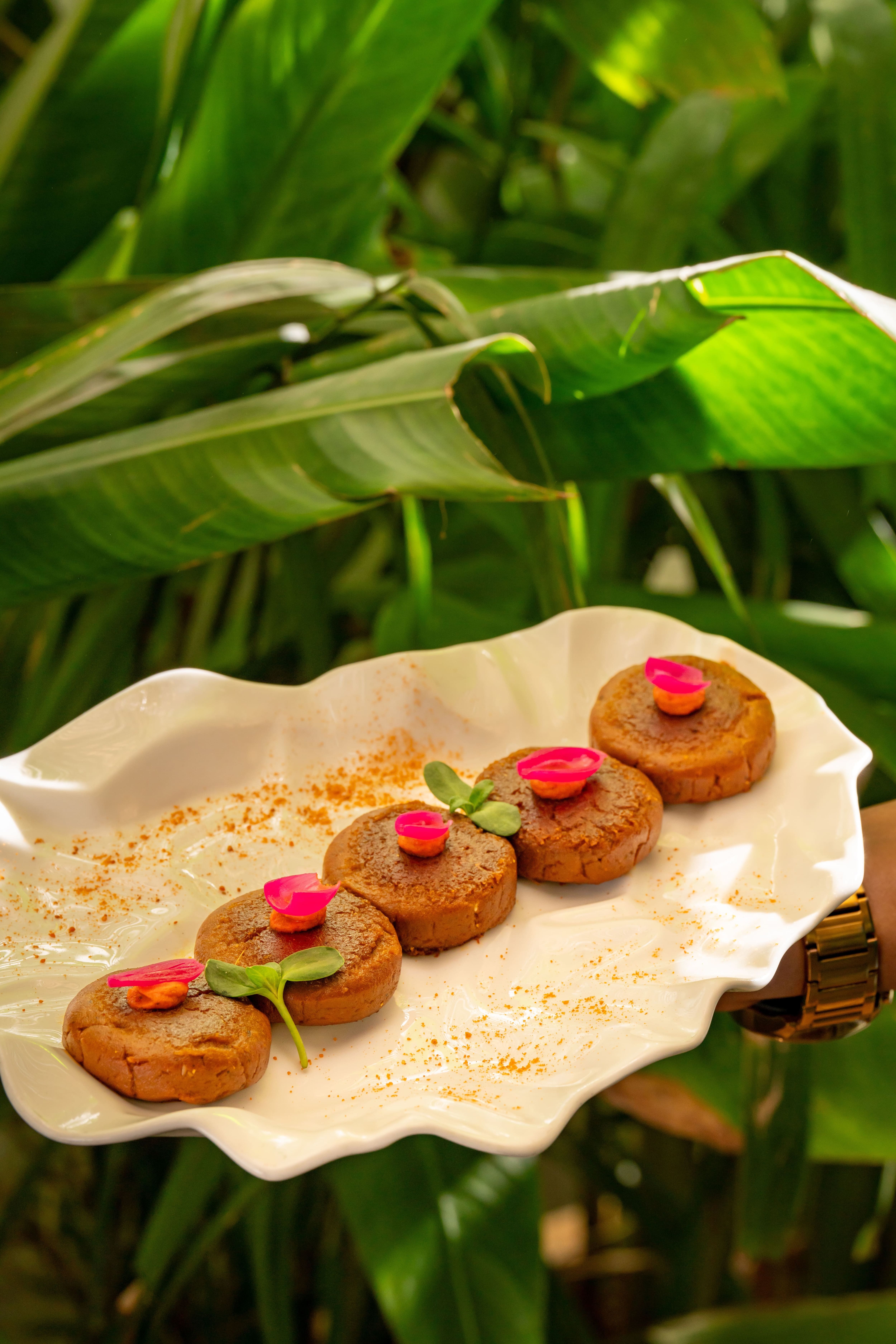 Plated kebab bites with petals and microgreens at Aidu Kitchen